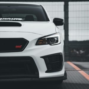 Close-up of a white Subaru WRX STI parked in an urban environment. Sporty and sleek.