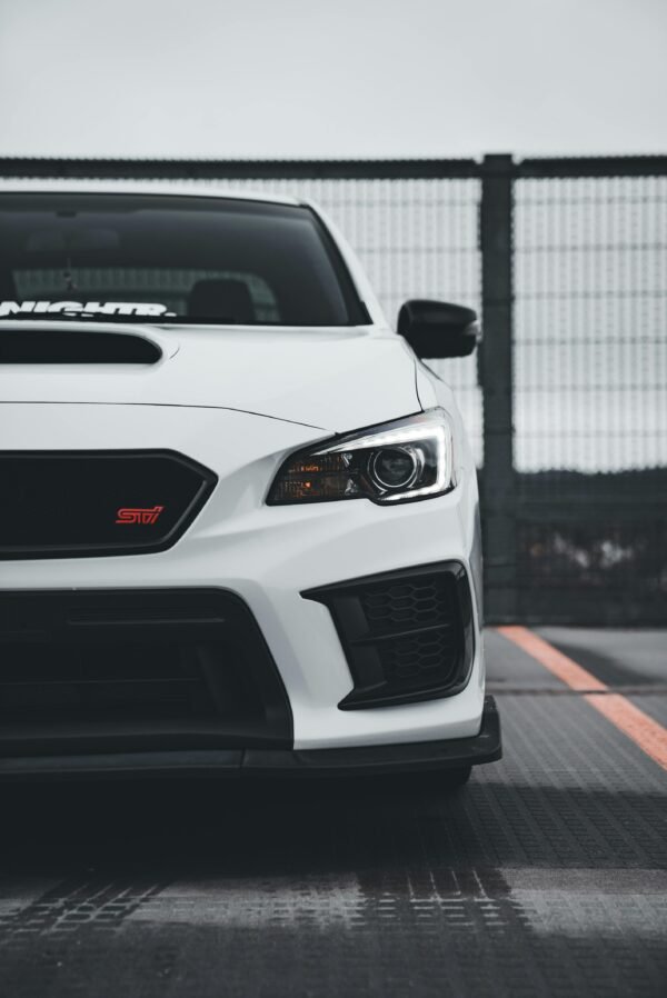 Close-up of a white Subaru WRX STI parked in an urban environment. Sporty and sleek.